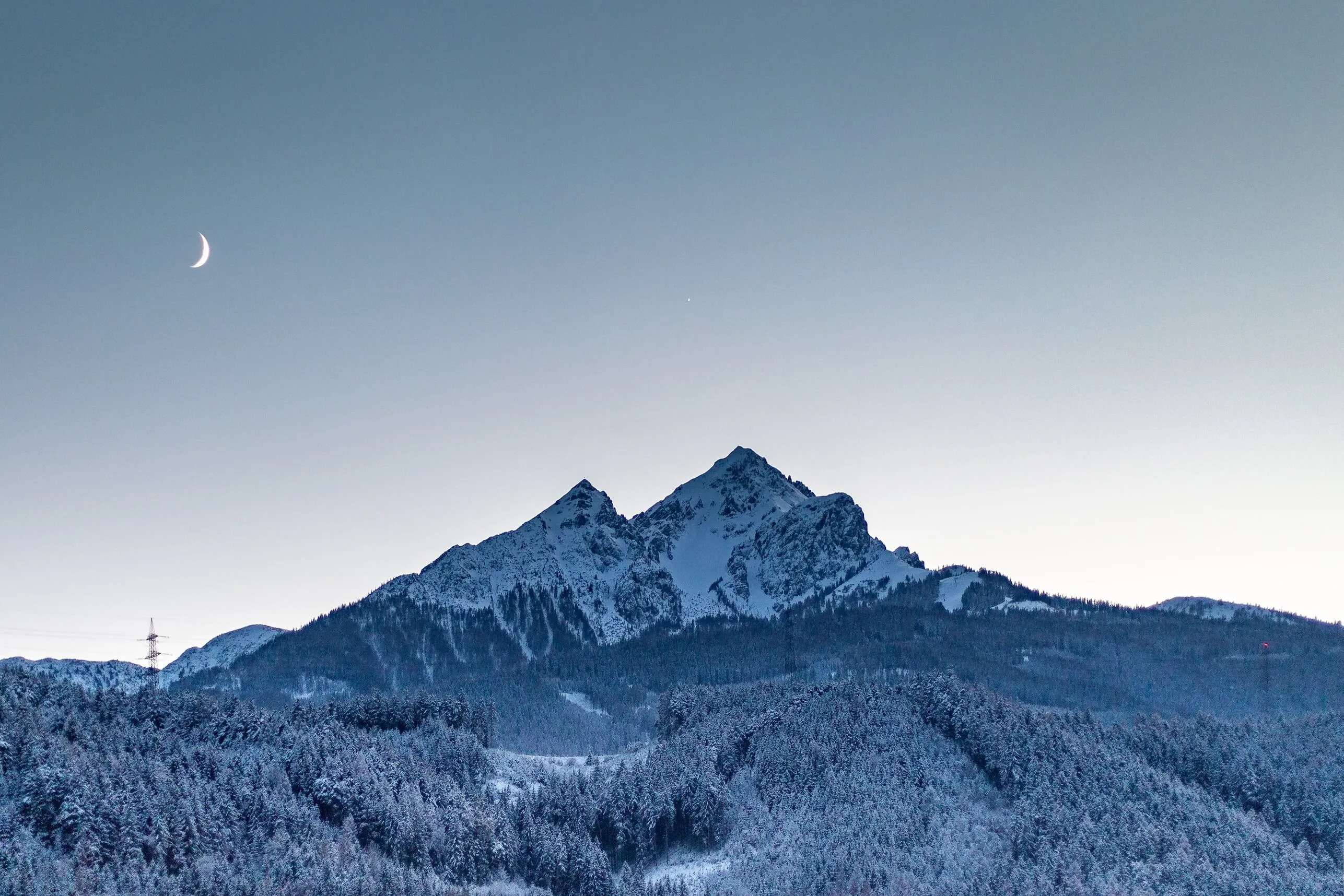 Wintery Nockspitze and the silhoutte of the moon with a peek of Jupiter above the peak